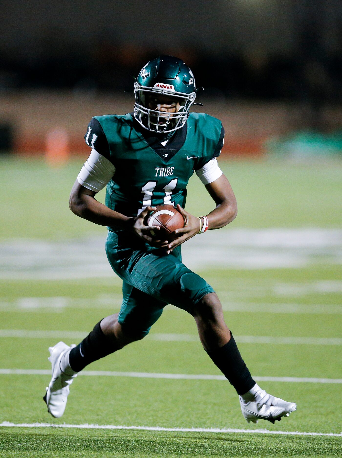 Waxahachie sophomore quarterback Roderick Hartsfield (11) carries the ball during the first...