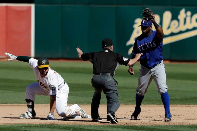 Oakland Athletics' Yonder Alonso, left, slides safely into second base with a double past...