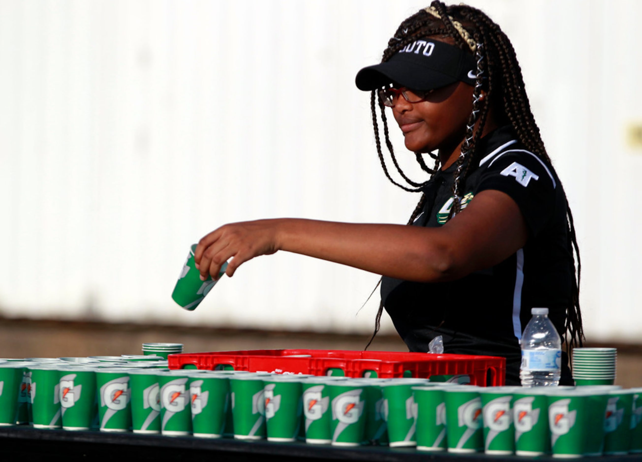 Desoto trainer Makayla Larkin prepares team drinks during the first half of the Bishop Dunne...