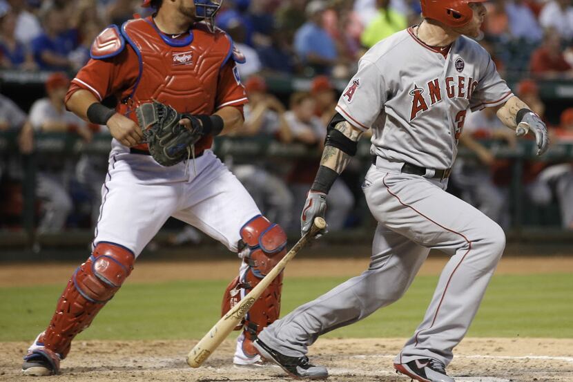 Los Angeles Angels' Josh Hamilton hits a single in front of Texas Rangers catcher Geovany...