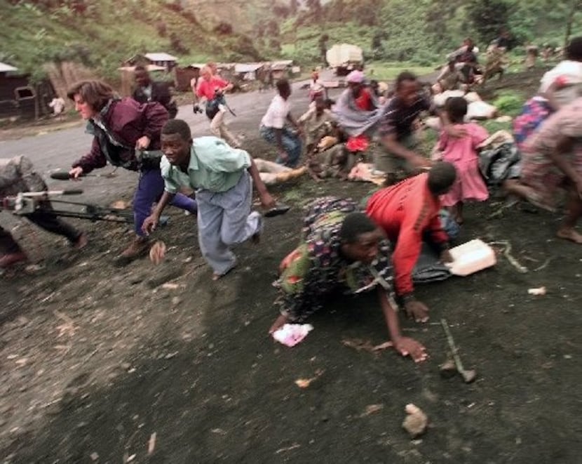 People run for cover as rebels fire shots as Rwandan refugees were making their way to the...