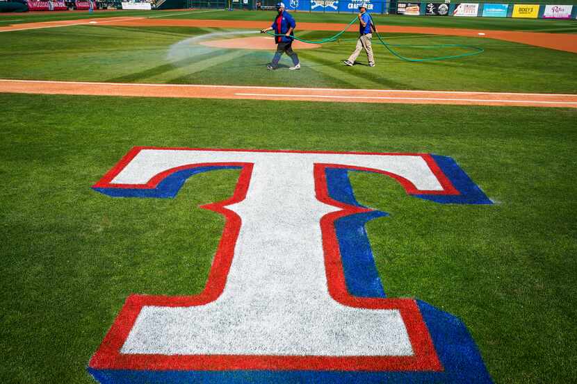 FILE - Groundskeepers prepare the field before a spring game between the Rangers and Kansas...