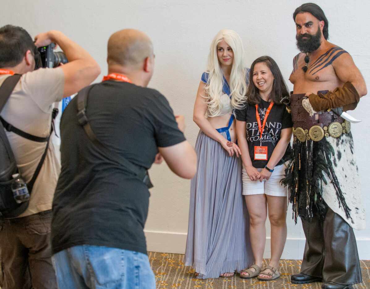 Con of Thrones cosplayers Daylon Walton, right, and Michelle Fanning, center, pose with a...