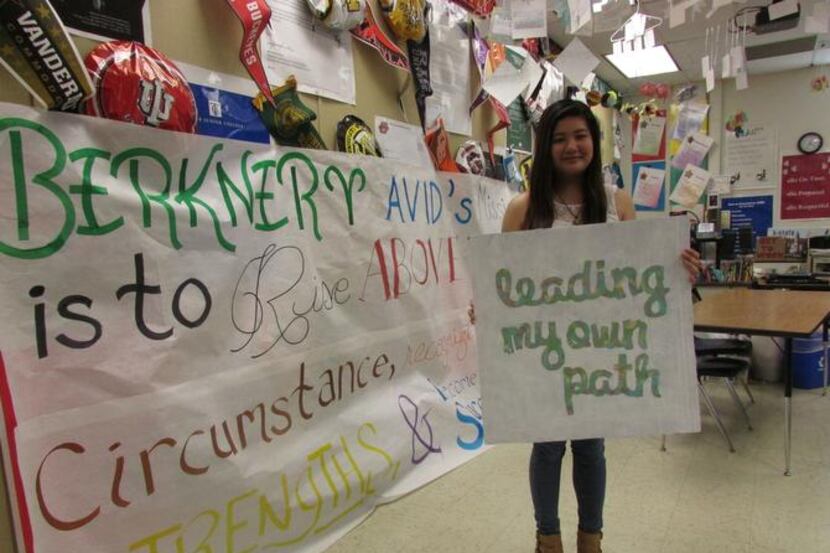 
L.V. Berkner High School senior Nancy Pham stands in the AVID classroom holding a poster...