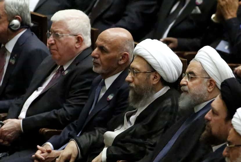 Iran's President Hassan Rouhani (third from the right) sits next to Judiciary Chief Sadeq...