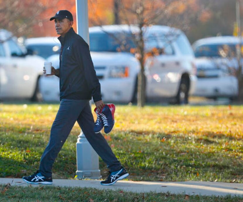 Obama carga un par de tenis en Fort McNair in Washington, Foto AP