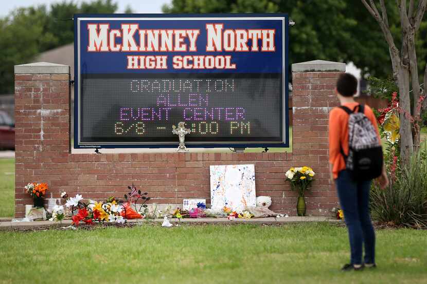A McKinney North High School student stopped to look at a makeshift memorial while leaving...