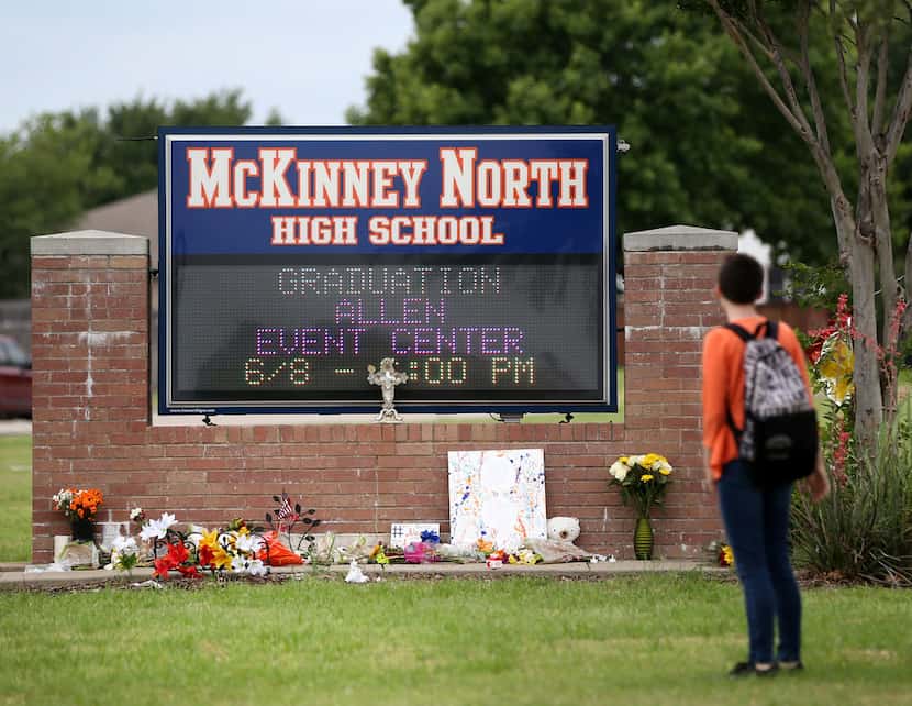 A McKinney North High School student stopped to look at a makeshift memorial while leaving...