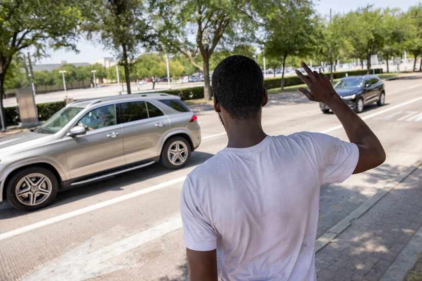 Alvin Jackson waves to cars at Park Lane and North Central Expressway on Tuesday, June 28,...