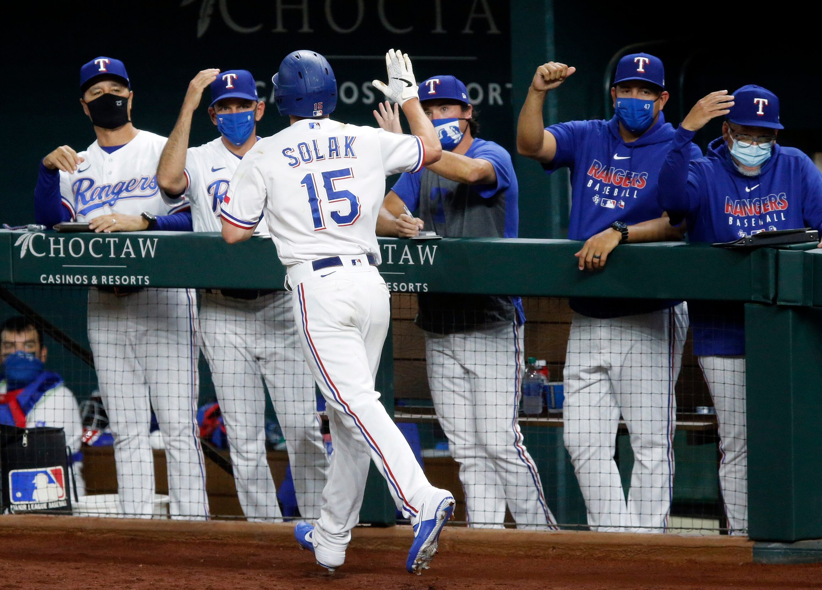 Texas Rangers Nick Solak (15) is congratulated by his coaches after scoring on a double by...