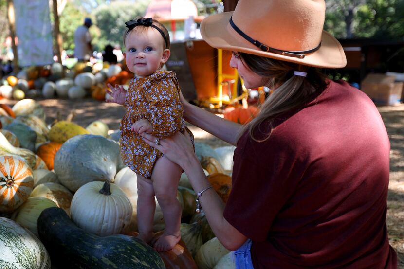 Sarah Clark holds 10-month-old Raegan in the Pumpkin Village at the Dallas Arboretum.