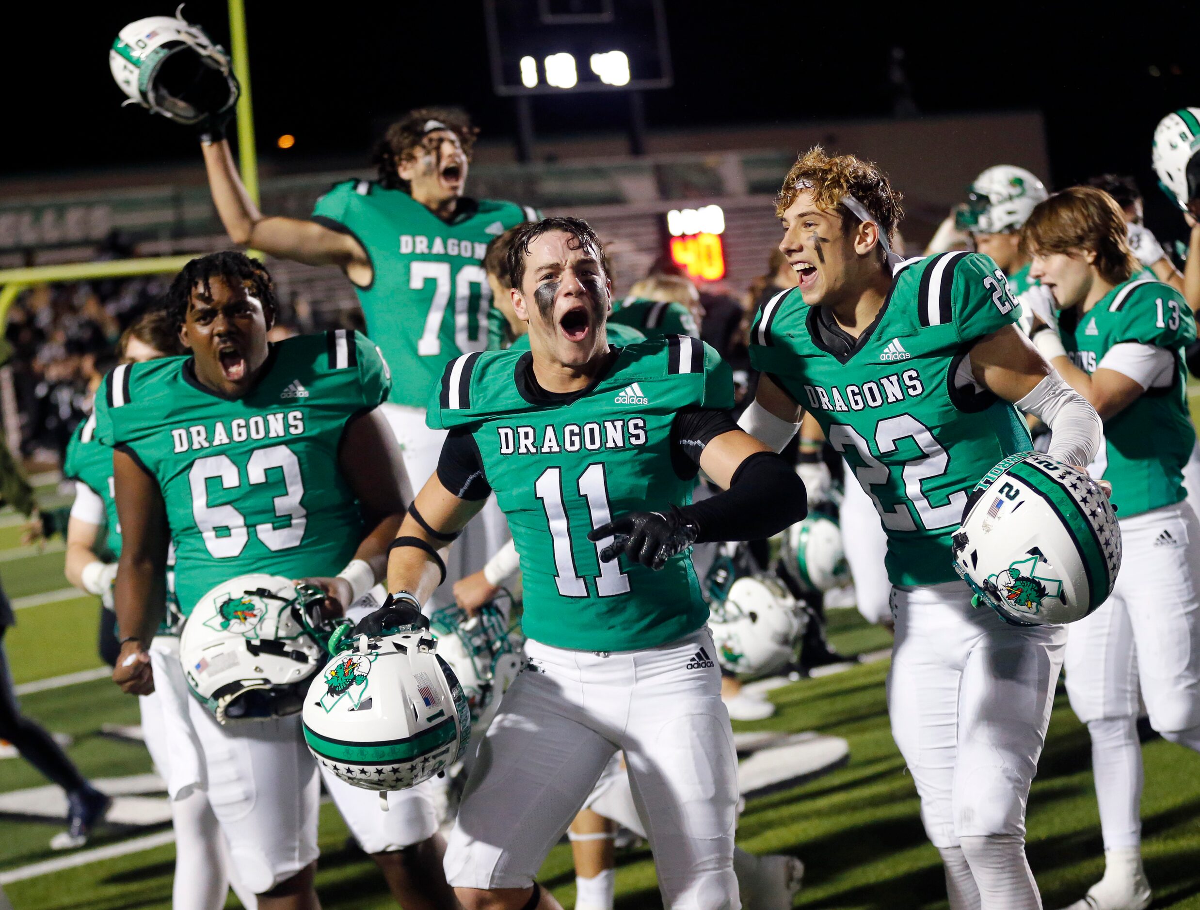 Southlake Carroll football players, including Graham Knowles (11) and Logan Lewandowski (22)...