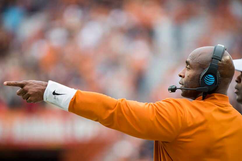Texas head coach Charlie Strong points to his players on the field during the first half of...