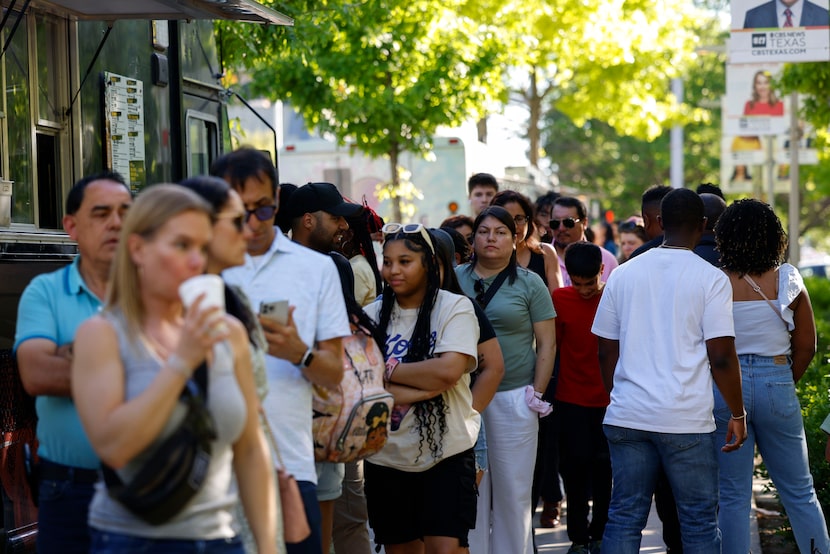 People remain in line for food truck at Klyde Warren Park, a day before total solar eclipse...