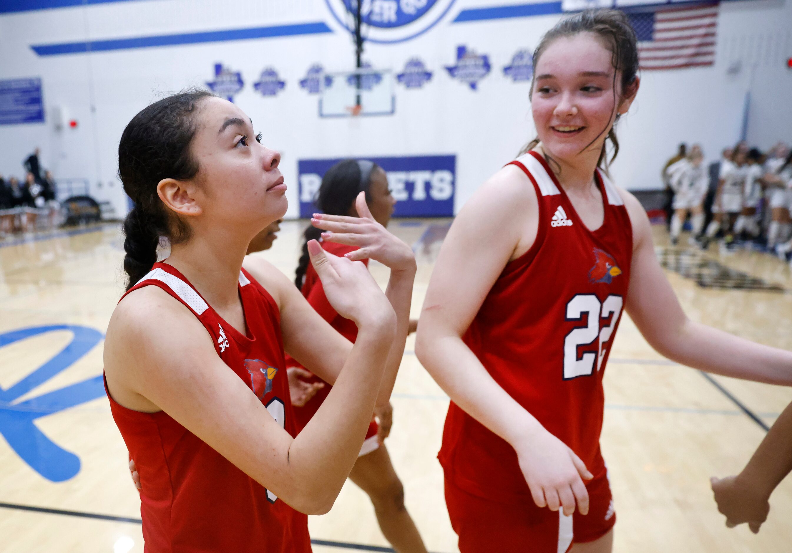 John Paul II senior guard Trinity Harris (left) fans herself as she is overcome with emotion...