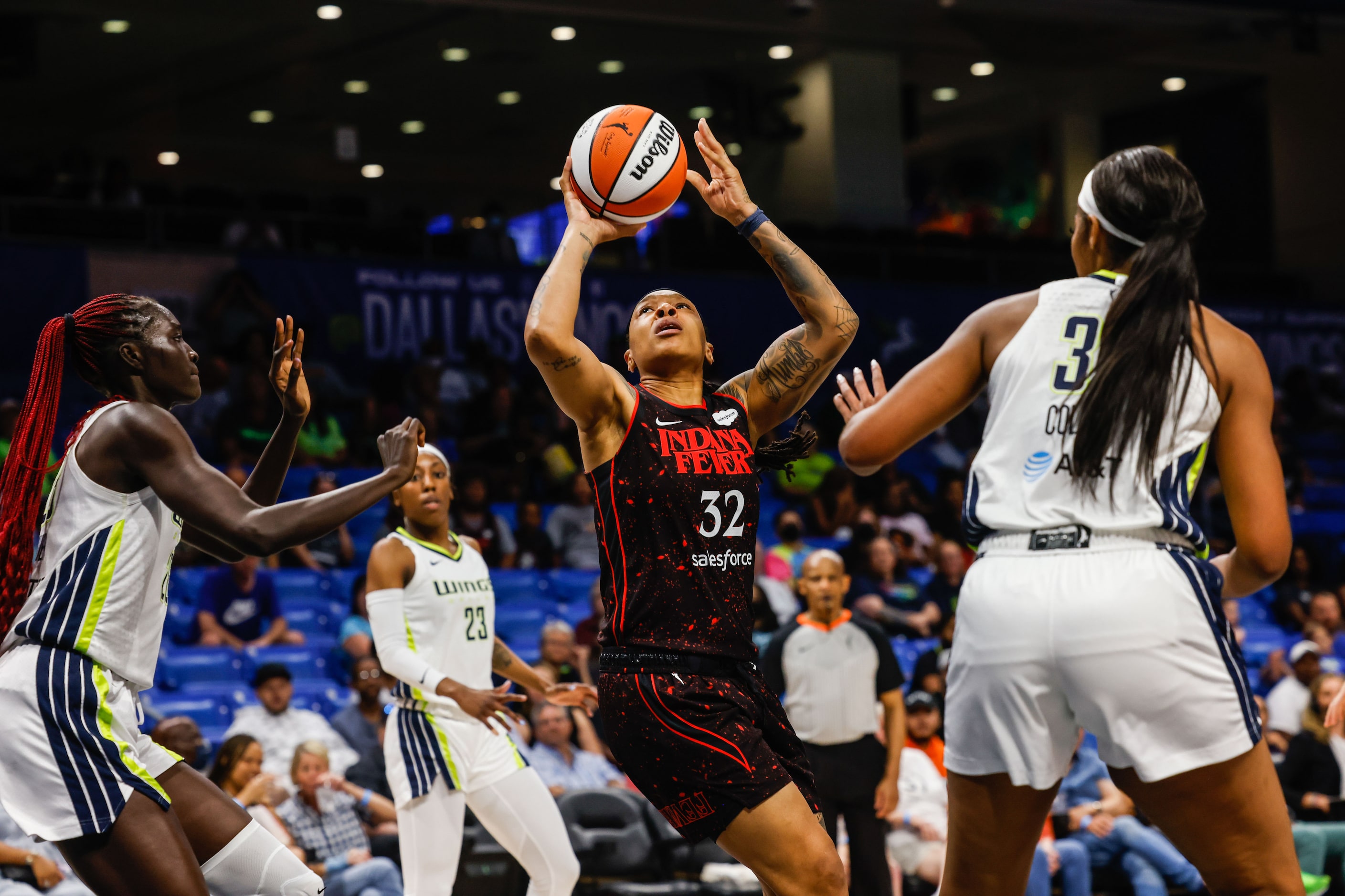 Indiana Fever Emma Cannon (32) goes for a shot between Dallas Wings center Awak Kuier (28)...