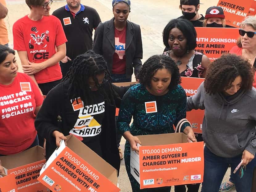 Cynthia Johnson (center), Botham Jean's girlfriend, delivers signatures to District Attorney...