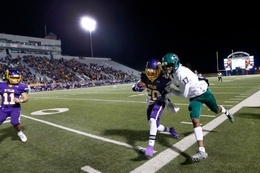 Abilene Wylie corner back Kendall Brown (20) makes an interception in front of Kennedale...