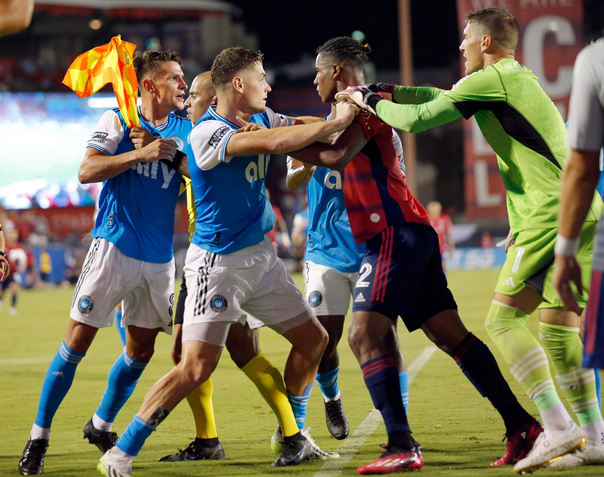 Players and an official try to separate Charlotte FC defender Jan Sobociński (2, left) and...