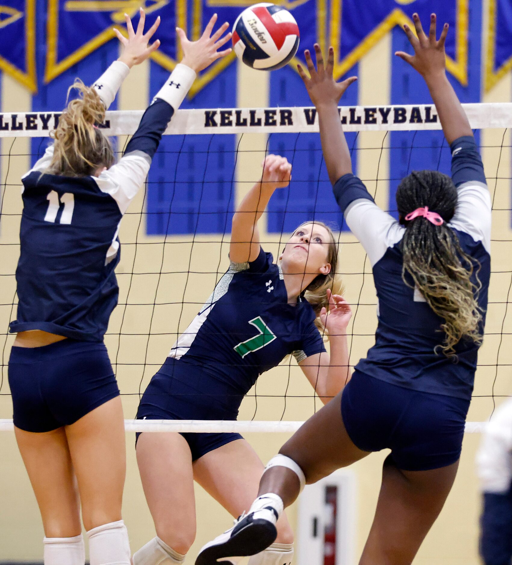 Eaton High’s Taylor Ashlock spikes the ball between Keller High’s Brooklyn Harter (11) and...