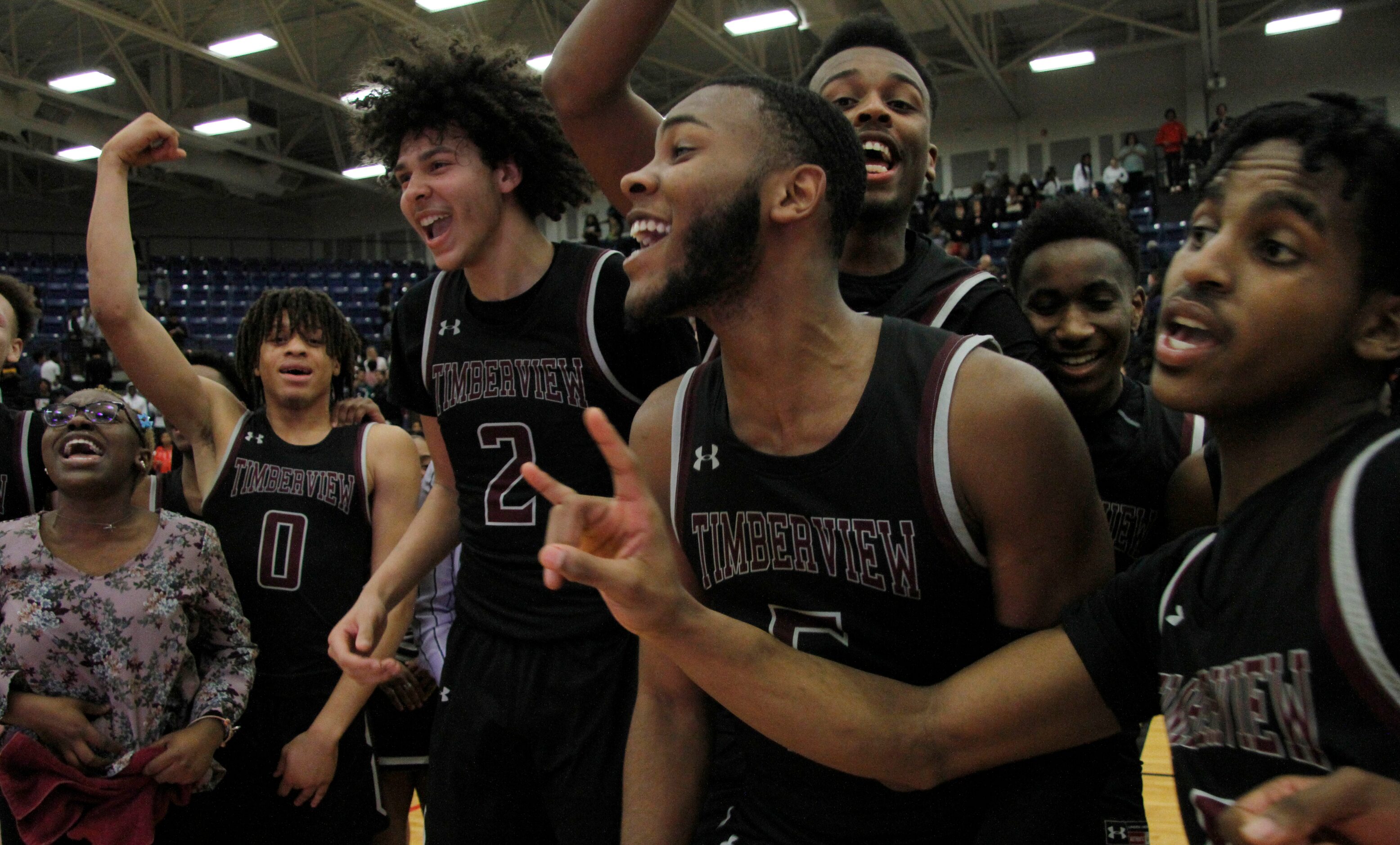 Members of the Mansfield Timberview varsity boys basketball team assemble at mid-court in...