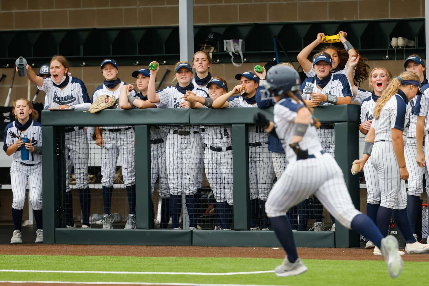 Flower Mound players cheer on teammate Katie Cantrell (20) during the fifth inning of a...