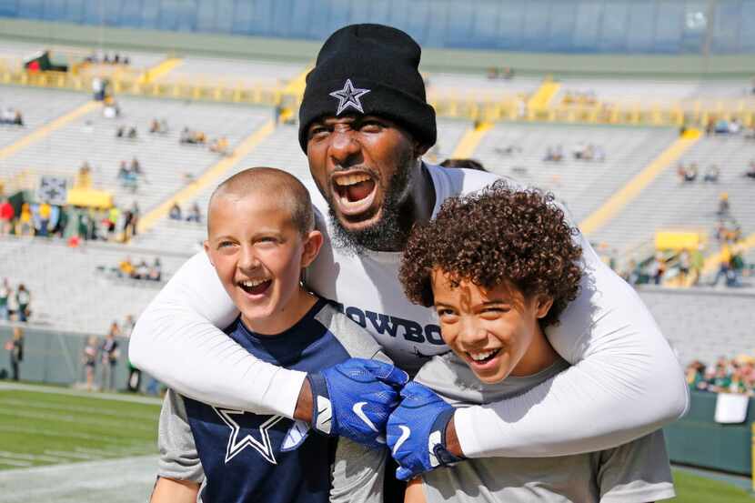 Dallas Cowboys wide receiver Dez Bryant (88) poses for a photo with youngsters Brock...