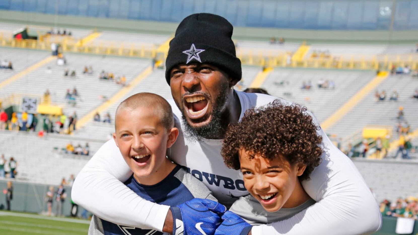 Dallas Cowboys wide receiver Dez Bryant (88) poses for a photo with youngsters Brock...