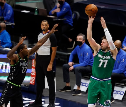 Mavericks guard Luka Doncic (77) attempts a shot over Timberwolves center Ed Davis (17)...