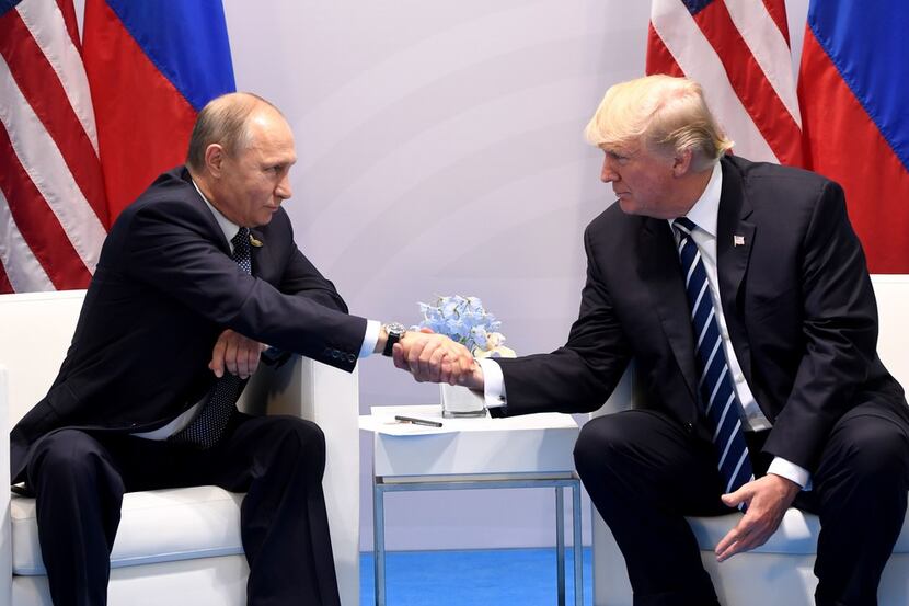 President Donald Trump (right) and Russia's President Vladimir Putin shake hands during a...