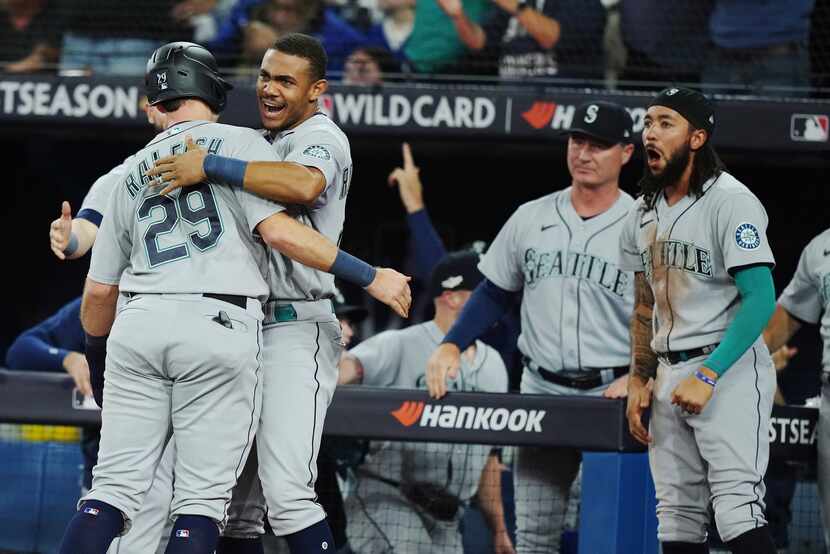 Seattle Mariners' Cal Raleigh (29) celebrates with Julio Rodriguez after scoring against the...