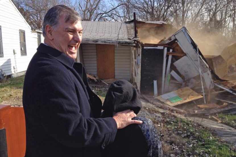 
Dallas Mayor Mike Rawlings and 10-year-old Juan Aguilar watch the destruction of a...