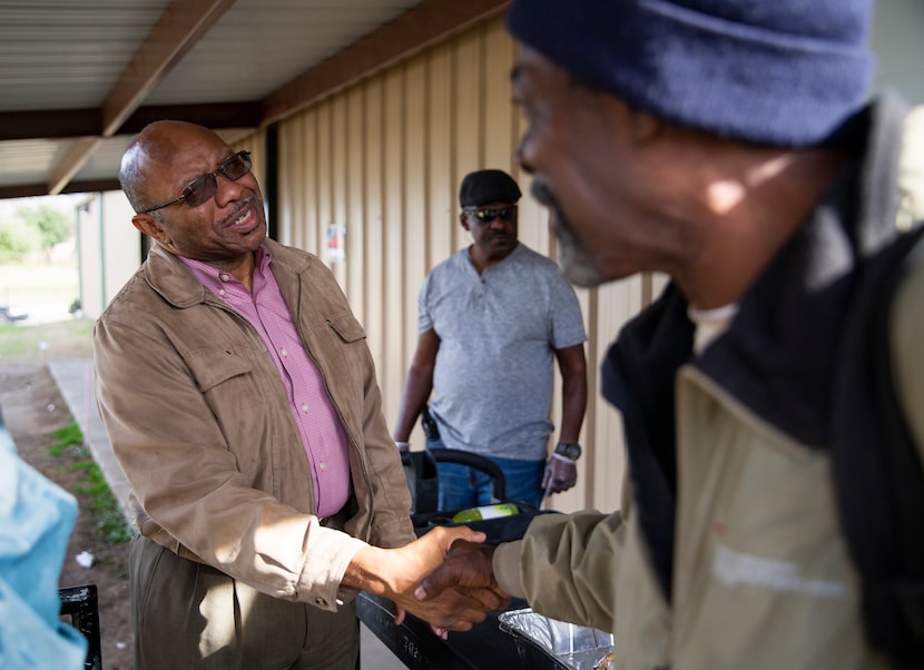 Pastor Chris Simmons (left) of Cornerstone Baptist Church in Dallas greets people as they...