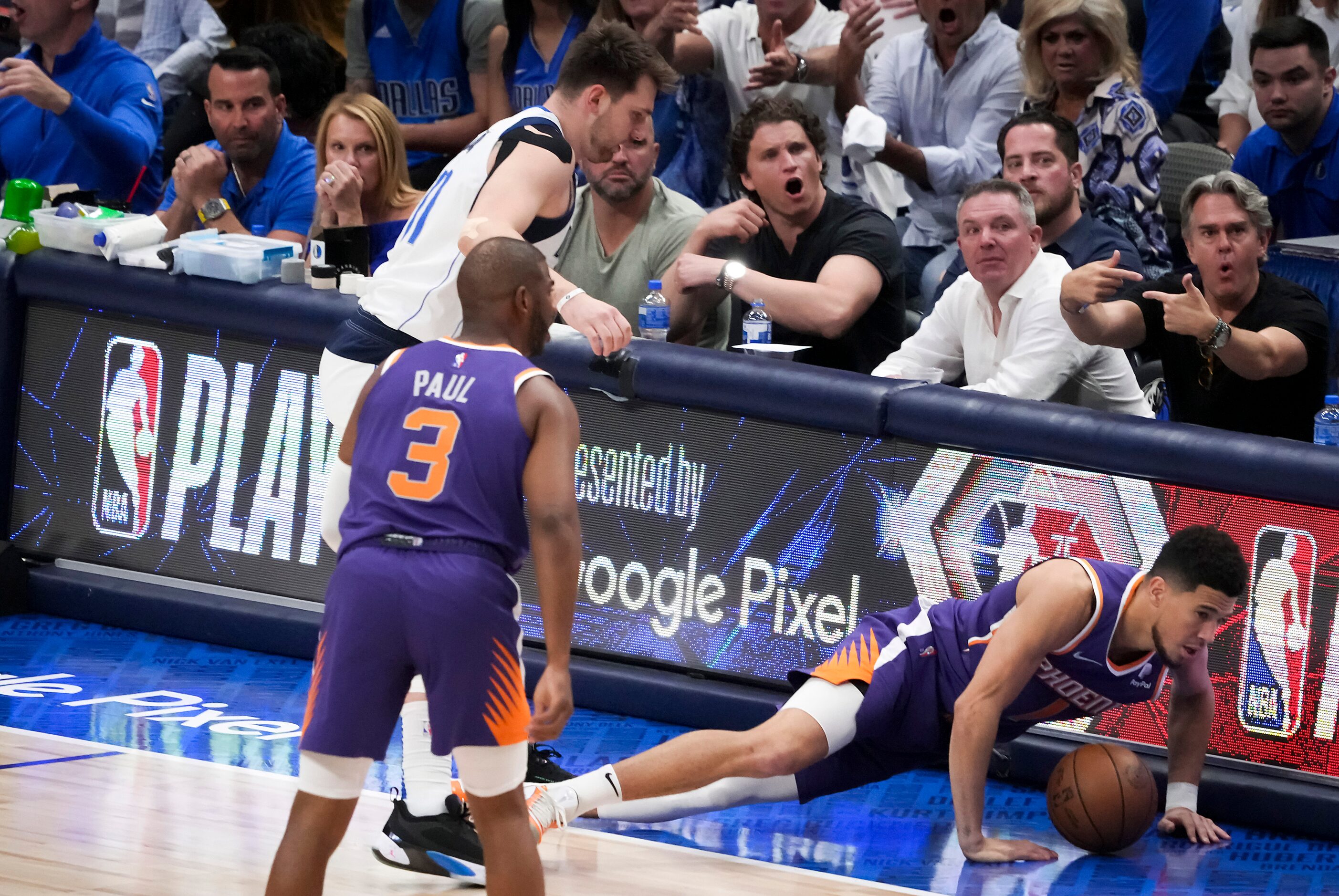 Phoenix Suns guard Devin Booker (1) falls out of bounds as Dallas Mavericks guard Luka...