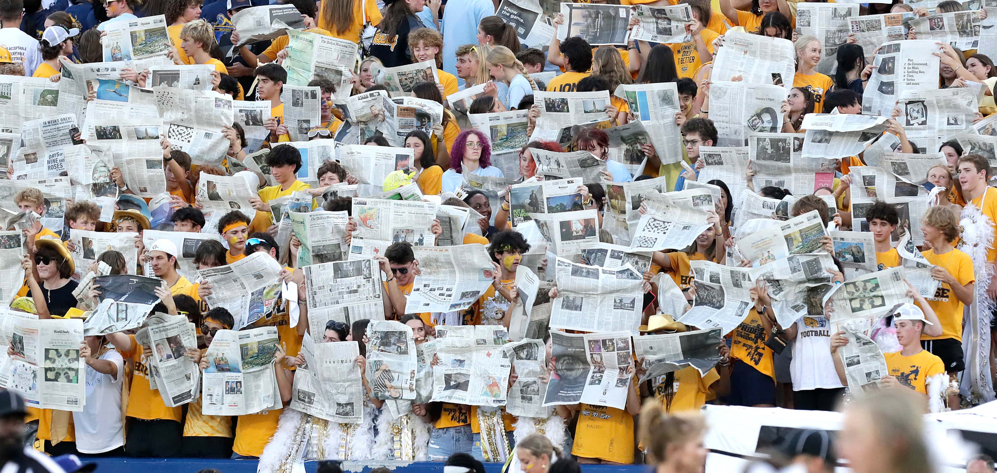 The McKinney High School student section quietly reads newspapers during the opposeing teams...