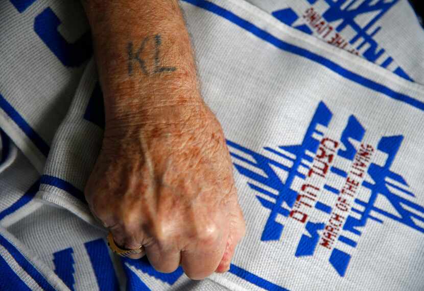 Max Glauben, a Holocaust survivor, shows the words "KL" tattoo, which stands in German for...