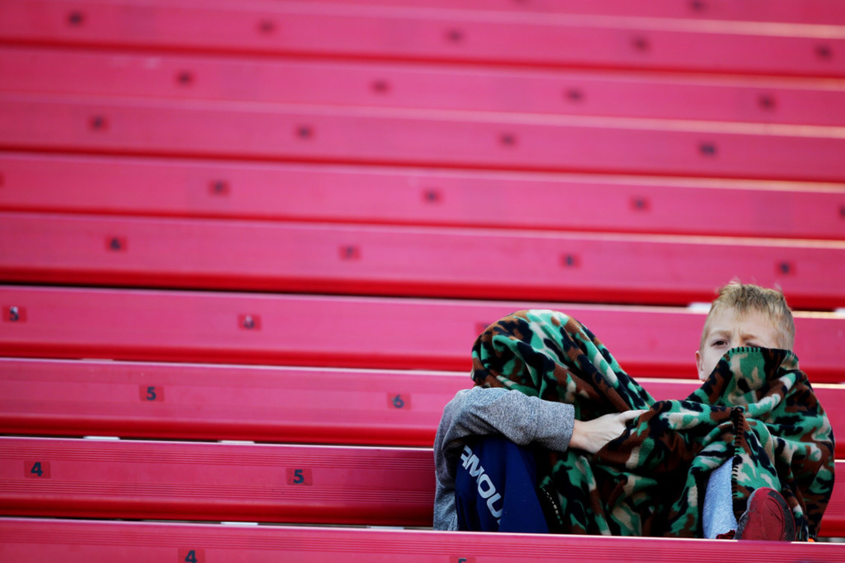 Children stay warm during the Class 5A Division II Region II final playoff high school...