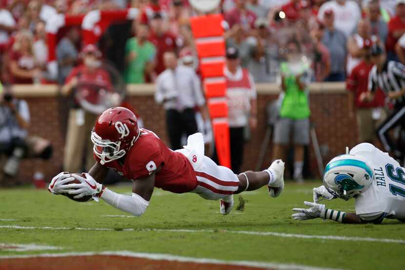 Oklahoma wide receiver CeeDee Lamb (9) dives into the end zone for a touchdown as Tulane's...