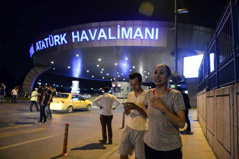 People stand outside Istanbul's Ataturk airport, Tuesday, June 28, 2016. Two explosions have...