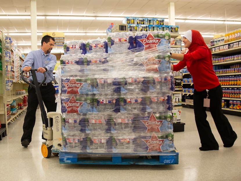 Maha Eldabaja, center store operations specialist, (right) helps Shaun Paeth, head of...