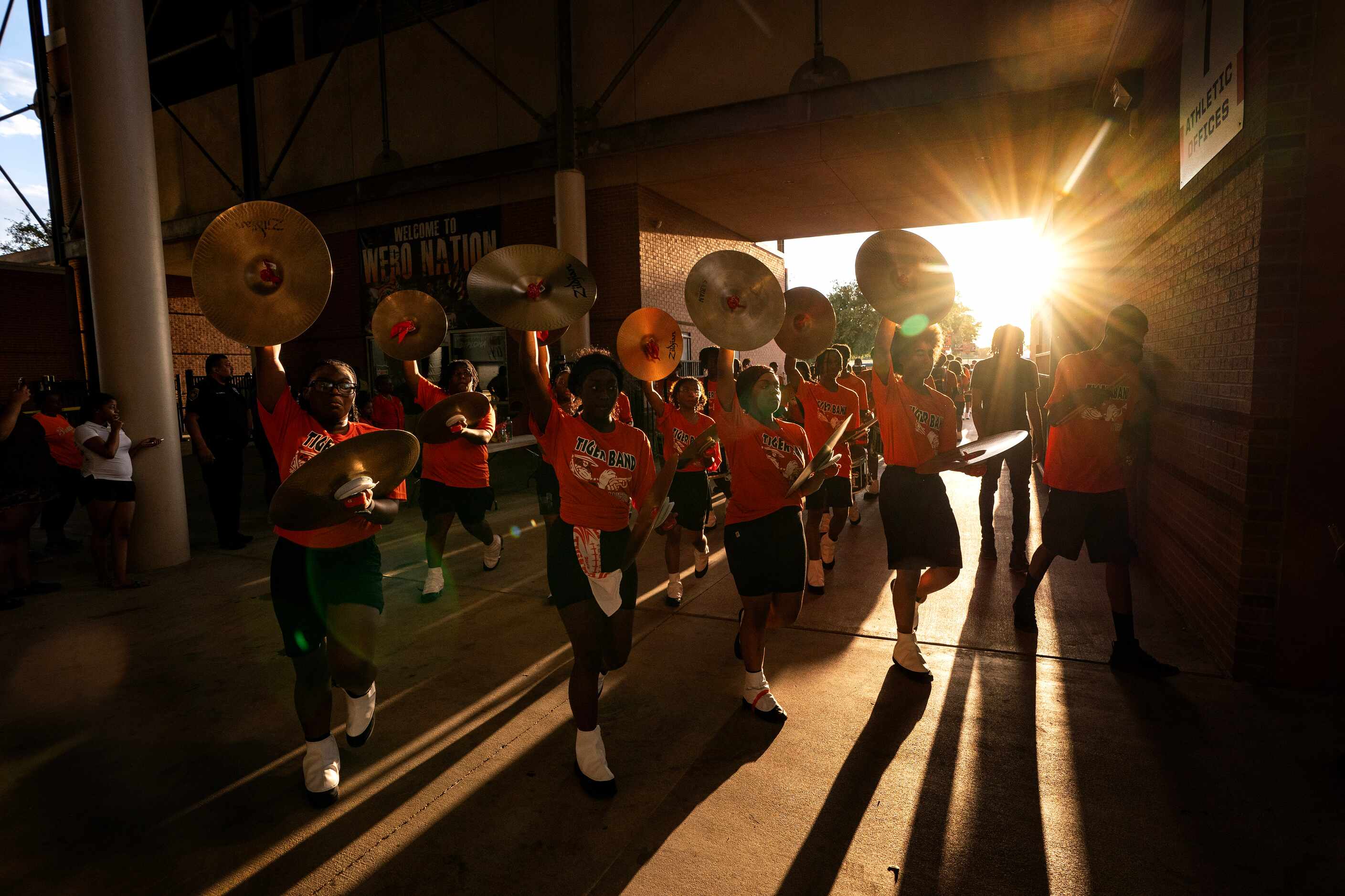 Cymbal players in the Lancaster band march into the stadium before a high school football...