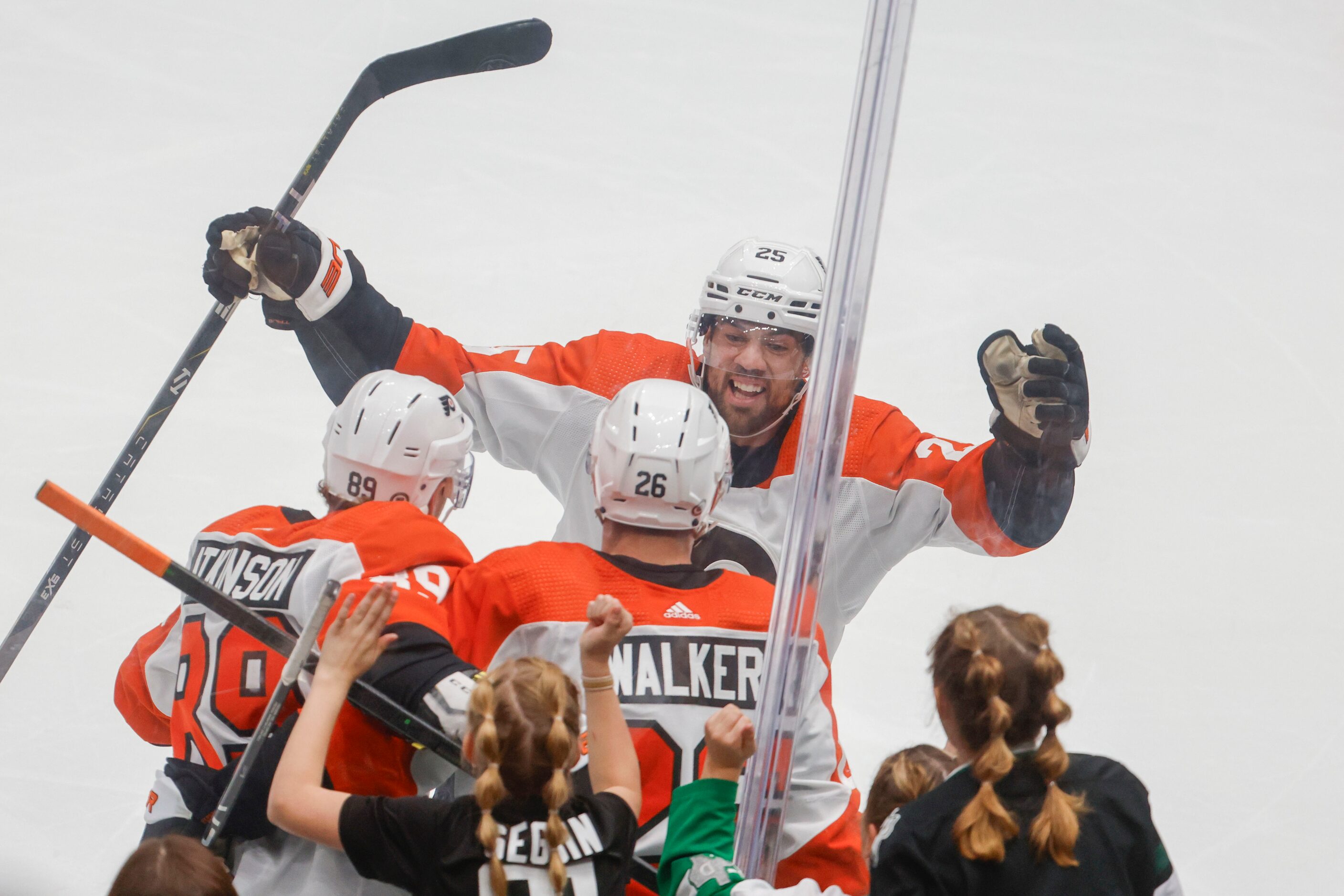 Philadelphia Flyers center Ryan Poehling (back) skates towards his teammates celebrating a...