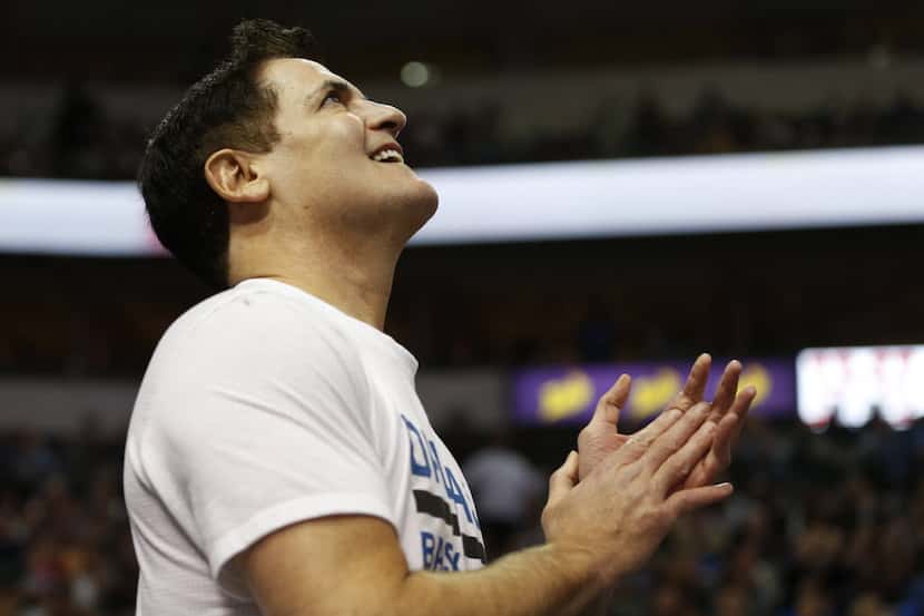 Dallas Mavericks owner Mark Cuban claps after a man proposes to his girlfriend on the...