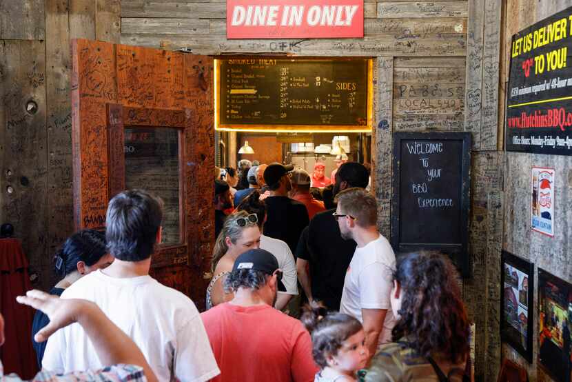 People stand in line to order food during the lunch hour at Hutchins BBQ, Friday, July 28,...