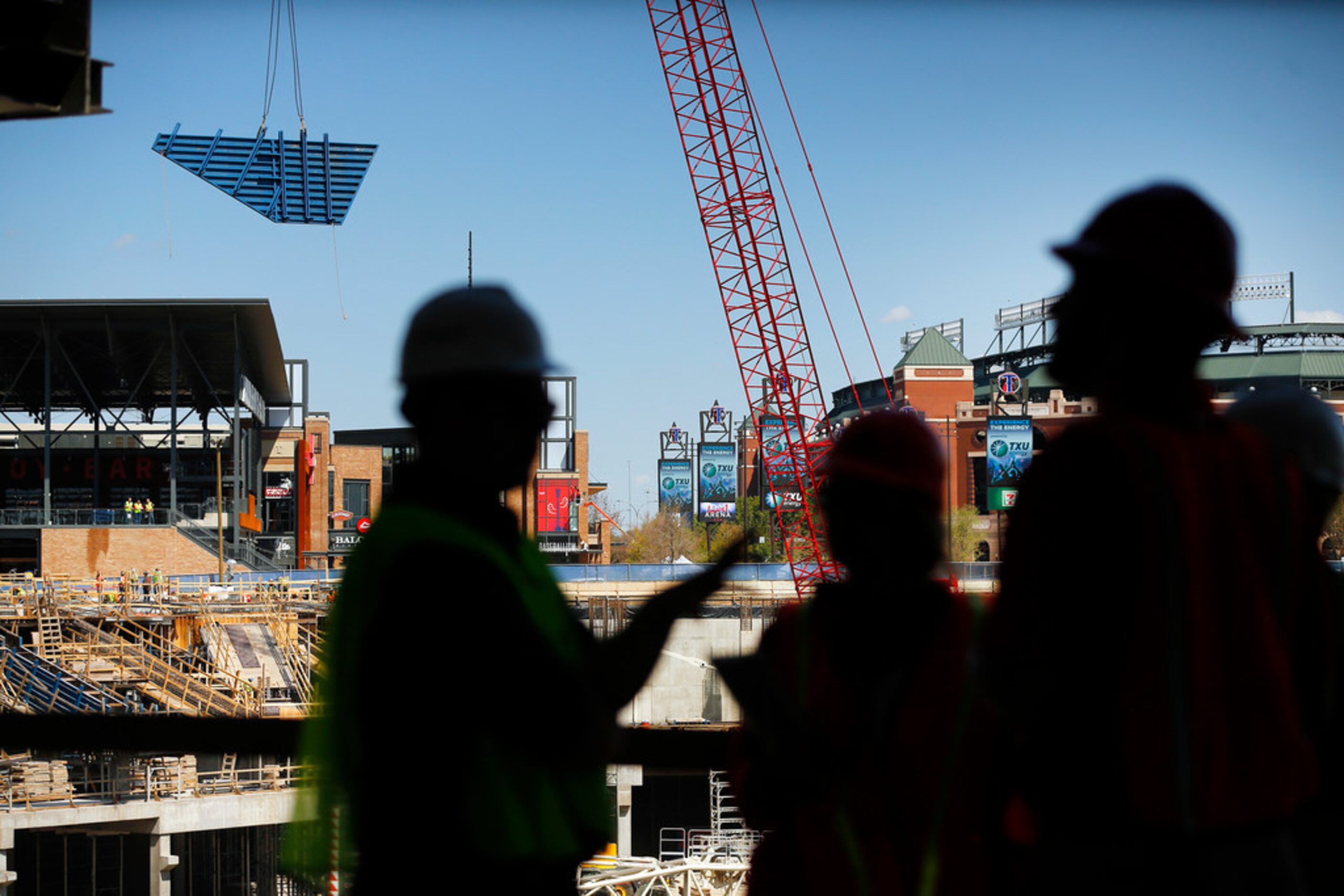 A large piece of decking is moved by a crane during a press event at the new Globe Life...