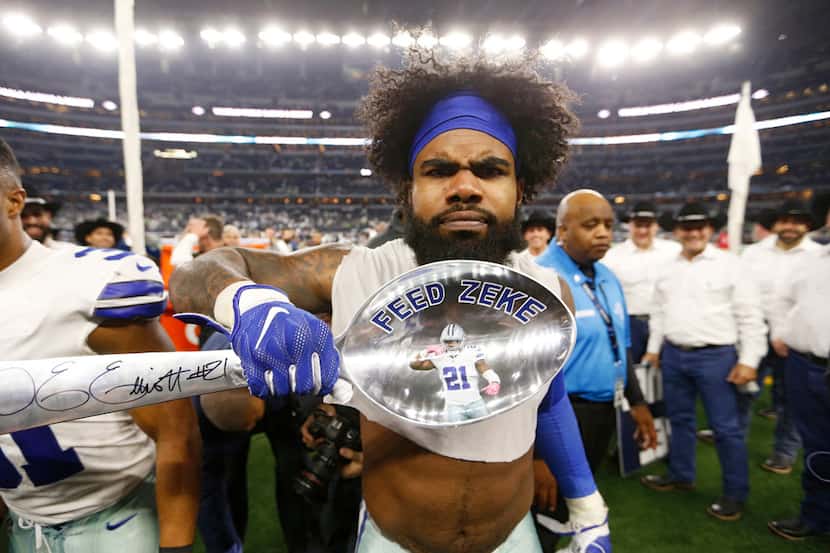 Dallas Cowboys running back Ezekiel Elliott (21) gestures his feed me after signing a giant...
