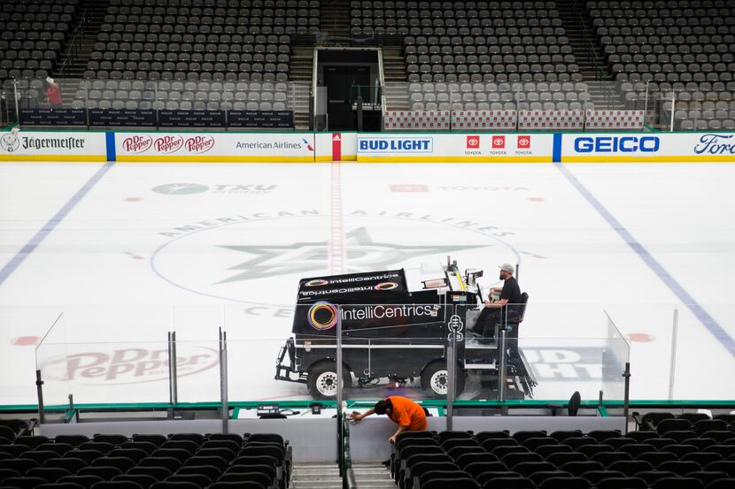 Crews clean and prepare to cover the Dallas Stars ice after all NHL were suspended due to...