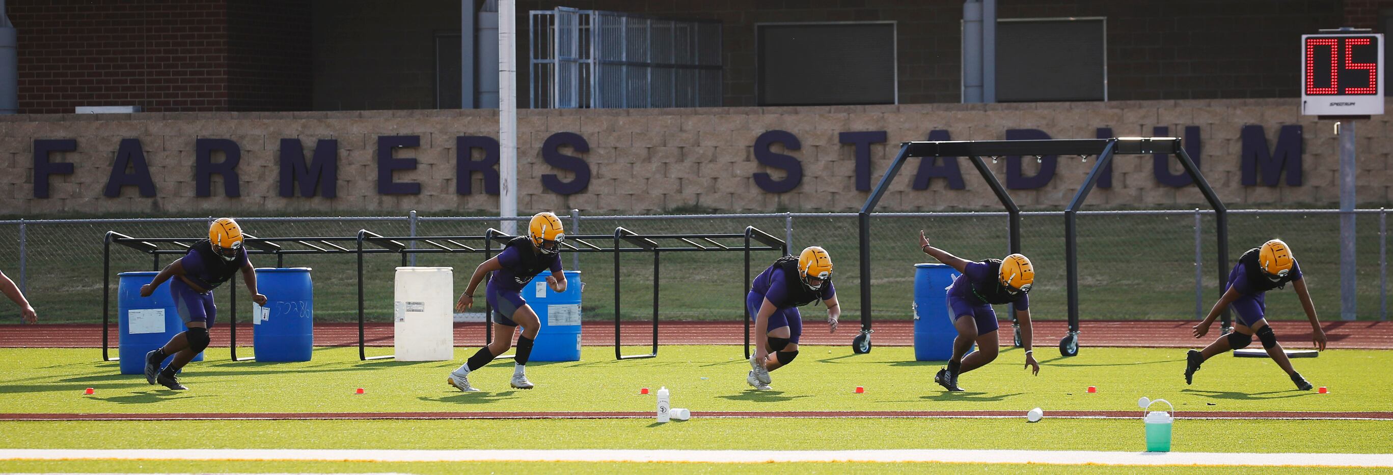 Players run through a drill during the first day of high school football practice for 4A's...