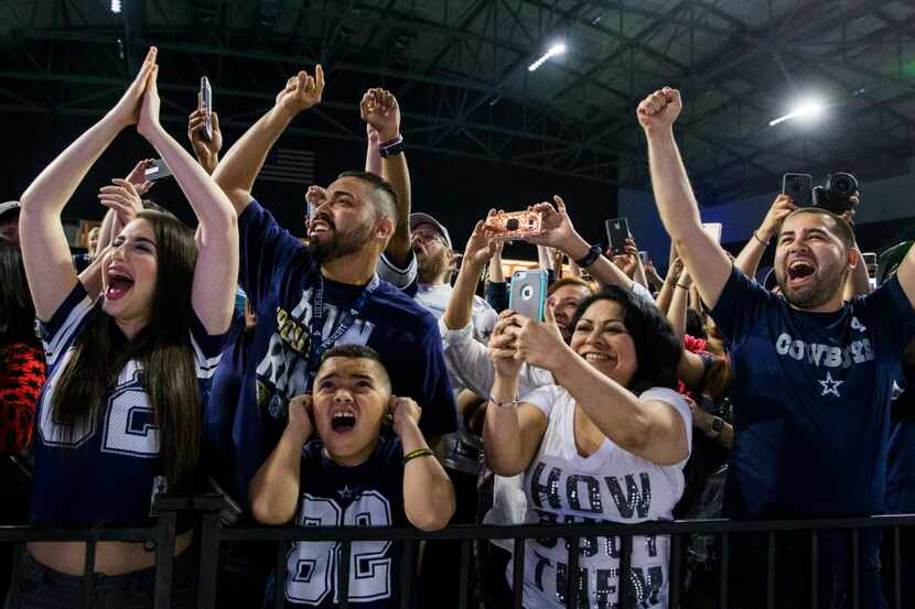 Dallas Cowboys fans cheer the Cowboys announce they have picked Taco Charlton in the first...