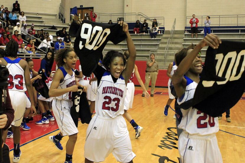 Duncanville players, including Alicia Spearmen (23) and Tasia Foman (20) hold up t-shirts...